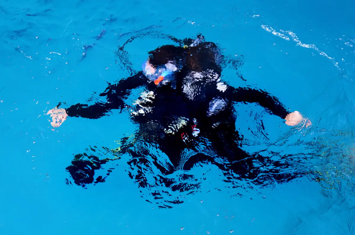 A scuba diver floating in clear blue water