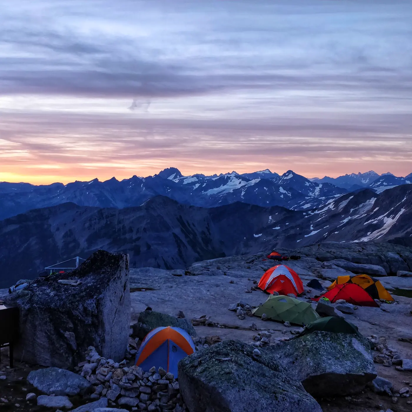 Tents on a rocky mountain top at sunrise
