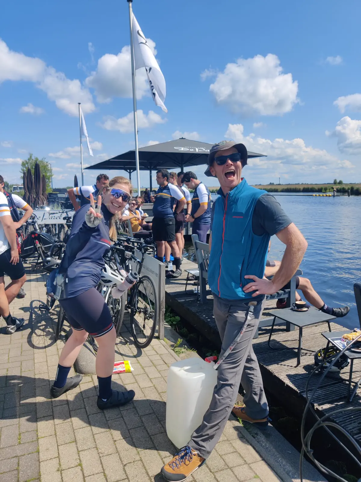 Tom laughing at a canal-side café stop with cyclists
